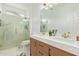 Bathroom with double sink vanity, white marble countertop, wood cabinets, and white marble and glass shower at 16609 N 40Th Dr, Phoenix, AZ 85053