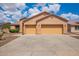 Spacious three-car garage with yellow doors and a wide concrete driveway, perfect for ample parking at 16609 N 40Th Dr, Phoenix, AZ 85053