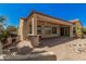 Outdoor patio area equipped with grill, bar, ceiling fans, and decorative rock water feature at 16704 W Oracle Rim Dr, Surprise, AZ 85387