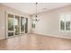 Bright dining room with tile floors, stylish chandelier, and sliding doors providing natural light at 16704 W Oracle Rim Dr, Surprise, AZ 85387
