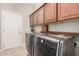 Efficient laundry room with ample cabinet space, countertops, and modern washer/dryer units at 16704 W Oracle Rim Dr, Surprise, AZ 85387