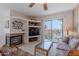 Bright living room featuring a fireplace, built-in shelves, and sliding glass doors overlooking pool at 16715 E El Lago Blvd # 212, Fountain Hills, AZ 85268