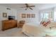 Bright main bedroom with ceiling fan, wooden dresser, and access to the screened in outdoor living area at 16715 E El Lago Blvd # 212, Fountain Hills, AZ 85268
