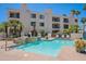 Inviting community pool area with waterfall feature, lounge chairs, and mature landscaping at 16715 E El Lago Blvd # 212, Fountain Hills, AZ 85268