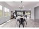 Open-concept dining area with wood-look tile flooring and modern chandelier, seamlessly connecting to the adjacent living spaces at 1914 N Marketside Ave, Buckeye, AZ 85396