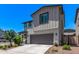 Front exterior of the home featuring a two-car garage, neutral-colored siding, and landscaped yard at 1914 N Marketside Ave, Buckeye, AZ 85396