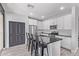 Bright kitchen with white cabinetry, stainless steel appliances, dark countertops, and island with barstool seating at 1914 N Marketside Ave, Buckeye, AZ 85396