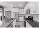 Modern kitchen with white cabinets, stainless steel appliances, dark countertops, and tile backsplash, providing a clean and sleek design at 1914 N Marketside Ave, Buckeye, AZ 85396