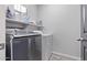 Functional laundry room with modern appliances, including a washer and dryer, and practical shelving at 1914 N Marketside Ave, Buckeye, AZ 85396