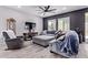Living room features gray sectional seating, TV and ceiling fan at 1914 N Marketside Ave, Buckeye, AZ 85396