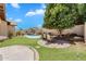 Landscaped backyard features a built-in barbecue, pool with a waterfall, and outdoor seating areas at 20507 W Daniel Pl, Buckeye, AZ 85396