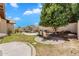 Spacious backyard with green grass, pond, and brick-paved patio with table and chairs at 20507 W Daniel Pl, Buckeye, AZ 85396
