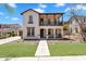 Charming two-story home with covered front porch, balcony, manicured lawn, and walkway at 20507 W Daniel Pl, Buckeye, AZ 85396