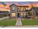 Charming two-story home showcasing stucco finish, landscaped lawn, covered balcony, and inviting curb appeal at sunset at 20507 W Daniel Pl, Buckeye, AZ 85396