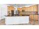 Spacious kitchen featuring wooden cabinetry, granite countertops, an island with seating, and stainless steel appliances at 20507 W Daniel Pl, Buckeye, AZ 85396