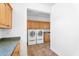 Convenient laundry room boasts front load washer/dryer, cabinets and utility sink at 20507 W Daniel Pl, Buckeye, AZ 85396