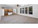 Spacious living room featuring carpet, windows, and view of the kitchen at 20507 W Daniel Pl, Buckeye, AZ 85396