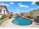 Backyard pool with stone waterfall feature is surrounded by mature landscaping for ultimate privacy at 20507 W Daniel Pl, Buckeye, AZ 85396