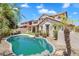 Backyard pool is surrounded by lush landscaping, rocks, and palm trees offering a private retreat at 20507 W Daniel Pl, Buckeye, AZ 85396