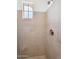Close-up of a tiled shower stall with a shower head and a window providing natural light at 20507 W Daniel Pl, Buckeye, AZ 85396
