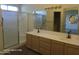 Bathroom featuring a double sink vanity with a large mirror and a walk-in shower at 20641 N 110Th Ave, Peoria, AZ 85373