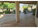 Covered patio with stone flooring looks out onto a landscaped yard with mature trees and bushes at 20641 N 110Th Ave, Peoria, AZ 85373