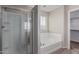 Modern bathroom showcasing a shower, a bathtub, and natural light from a window, all pristine white at 21039 E Avenida Del Valle --, Queen Creek, AZ 85142