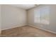 Cozy bedroom with a large window providing natural light, complemented by neutral walls and carpet at 21039 E Avenida Del Valle --, Queen Creek, AZ 85142