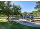 Community playground with picnic tables surrounded by a large grassy field and mature trees at 21039 E Avenida Del Valle --, Queen Creek, AZ 85142