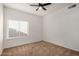 A simple bedroom with neutral carpet features a ceiling fan and window with blinds at 2226 N Gentry --, Mesa, AZ 85213