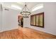 Elegant dining area featuring hardwood floors, chandelier, and plantation shutters at 2226 N Gentry --, Mesa, AZ 85213