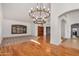 Elegant living area showcasing hardwood flooring, neutral carpet, striking chandelier and shuttered windows at 2226 N Gentry --, Mesa, AZ 85213