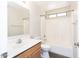 Bathroom with wood cabinets and white sink features a bathtub with shower combo at 2698 E Denim Trl, San Tan Valley, AZ 85143