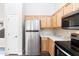 Modern kitchen showcasing stainless steel refrigerator, wooden cabinets and countertops and a door for extra storage at 2698 E Denim Trl, San Tan Valley, AZ 85143