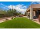 Expansive backyard with green lawn, a luxurious pool, and a covered patio at 3055 N Red Mtn # 77, Mesa, AZ 85207