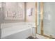 Bright bathroom with a soaking tub, a walk-in shower, and plantation shutters on the garden window at 3055 N Red Mtn # 77, Mesa, AZ 85207