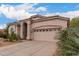 Close up of front of stucco home with tile roof, desert landscaping, and attached garage at 3055 N Red Mtn # 77, Mesa, AZ 85207