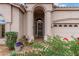 Up close front entrance with arched doorway, desert landscaping, and a two car garage at 3055 N Red Mtn # 77, Mesa, AZ 85207