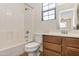 Clean bathroom featuring a shower-tub, tiled walls, and vanity with storage at 3535 E Erie St, Gilbert, AZ 85295