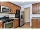 Modern kitchen with stainless steel appliances, gas range, and warm wood cabinetry at 3535 E Erie St, Gilbert, AZ 85295