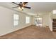Bright living room with neutral carpet, access to back patio, staircase, and overhead lighting at 3535 E Erie St, Gilbert, AZ 85295