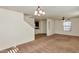 Large living room featuring neutral colored carpet, staircase, view to kitchen, and modern ceiling fan at 3535 E Erie St, Gilbert, AZ 85295