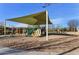 Community playground with tan shade structure, slides, climbing features, and swing sets at 3535 E Erie St, Gilbert, AZ 85295