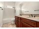 Bathroom with dual sinks, dark wood vanity, and bath tub at 3715 S Skyline Dr, Gilbert, AZ 85297