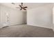 Spacious bedroom featuring neutral carpet, a ceiling fan, and a door to another room at 3715 S Skyline Dr, Gilbert, AZ 85297