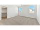 Bright bedroom with neutral carpet, two windows providing natural light, and a walk-in closet for ample storage at 37582 W San Clemente St, Maricopa, AZ 85138