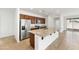 Bright open kitchen featuring stainless steel appliances, wood cabinets, granite countertops, and a large kitchen island at 37582 W San Clemente St, Maricopa, AZ 85138