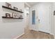 Bright entryway features wood-look floors, floating shelves, and a white front door with sidelight window at 3865 E Dogwood Pl, Chandler, AZ 85286