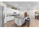 Bright kitchen featuring white cabinetry, stainless appliances, dark countertops, and an island with barstool seating at 3865 E Dogwood Pl, Chandler, AZ 85286