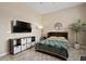 Comfortable bedroom with neutral walls, a ceiling fan, and a sleek TV and shelving unit at 42 S Nevada Way, Gilbert, AZ 85233